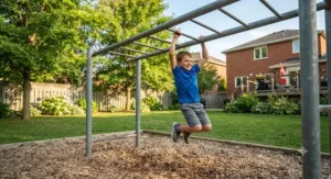 A young child developing upper body strength and coordination on backyard monkey bars