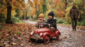 Two toddlers cruising through colorful autumn leaves in a rugged two-seater electric ride-on car for two kids in Canada.